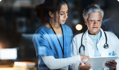 A doctor and nurse review a patient chart on a tablet, symbolizing the use of technology in patient care.